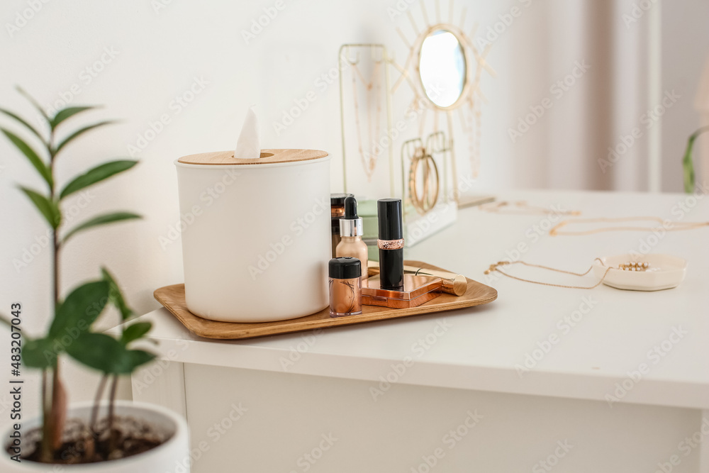 Tray with decorative cosmetics and jewelry on white table