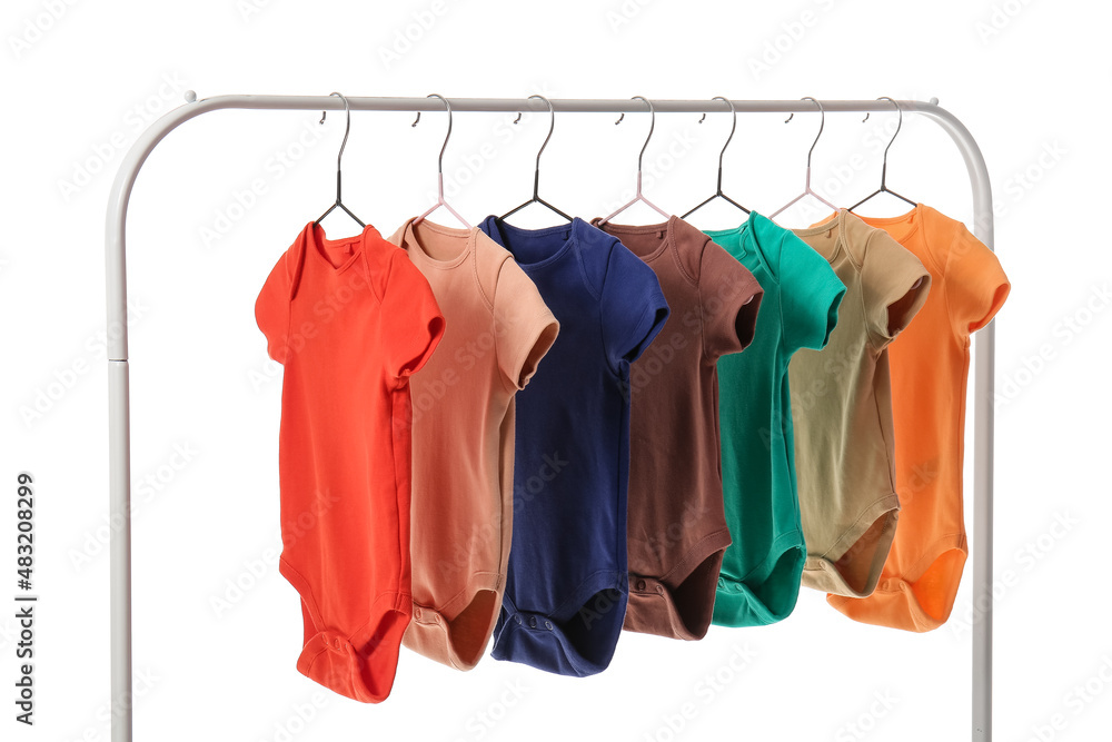 Rack with different baby bodysuits on white background