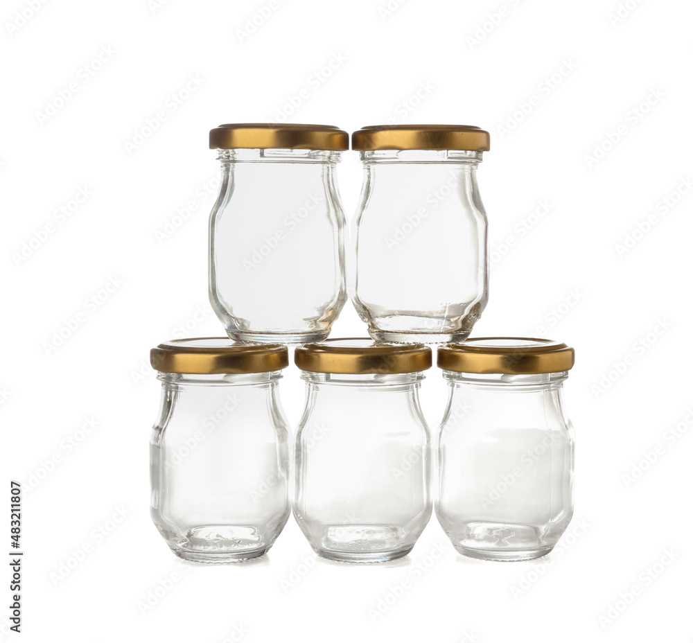 Empty glass jars with golden caps on white background