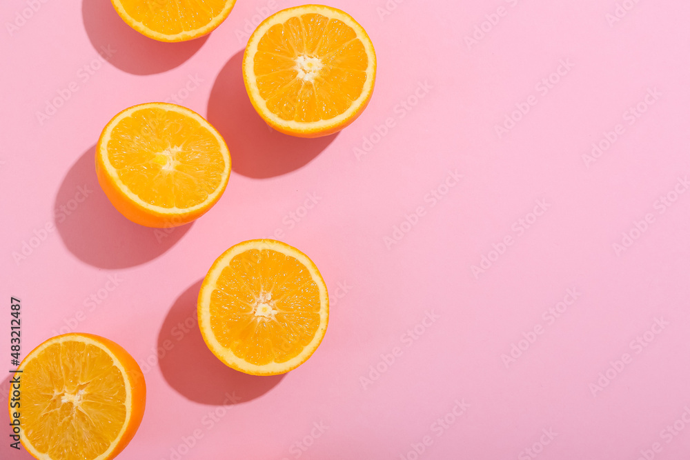 Fresh cut oranges on pink background