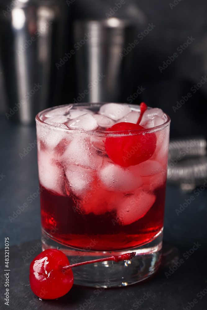 Glass of tasty Manhattan cocktail on black background