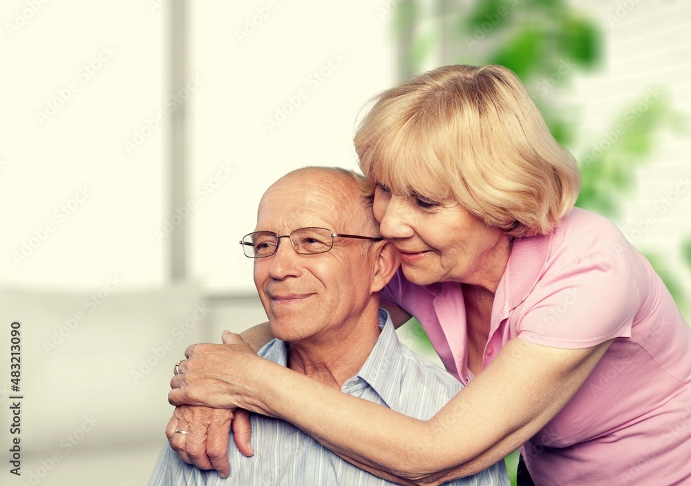 old retired age couple watching TV at home, on sofa couch at living room home