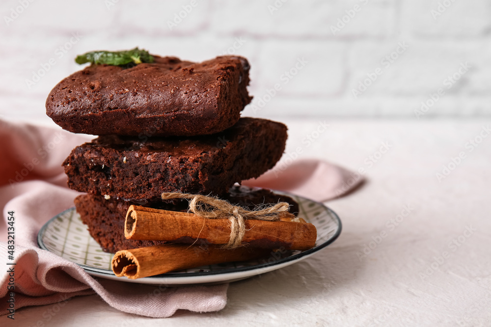 Plate with pieces of tasty chocolate brownie on table