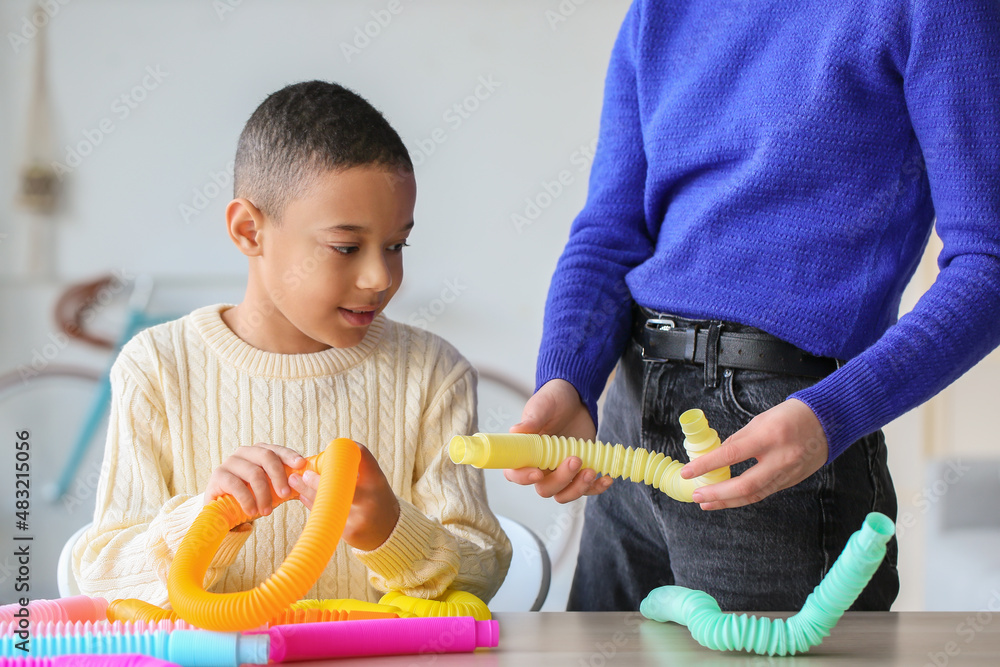 Woman giving Pop Tube to little boy at home