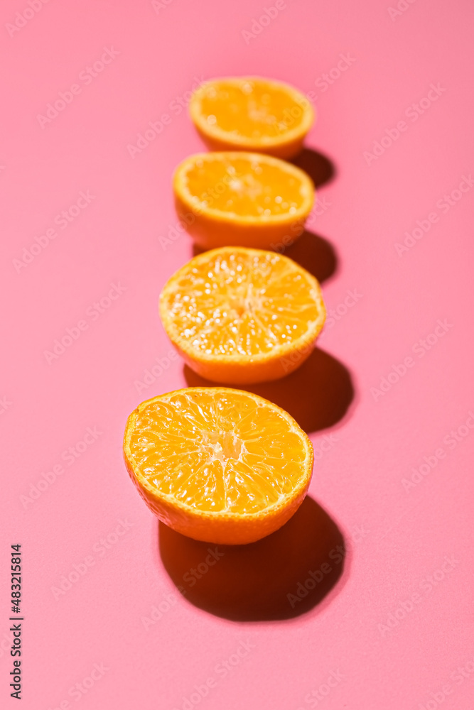 Cut juicy tangerines on color background