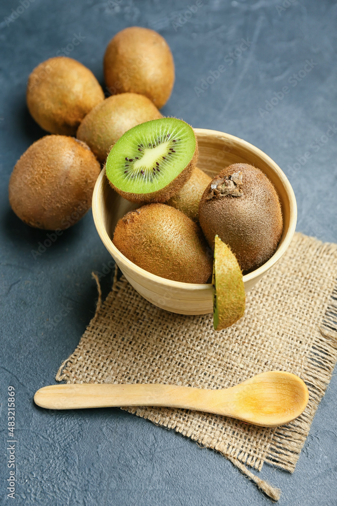 Bowl with fresh kiwi on black background