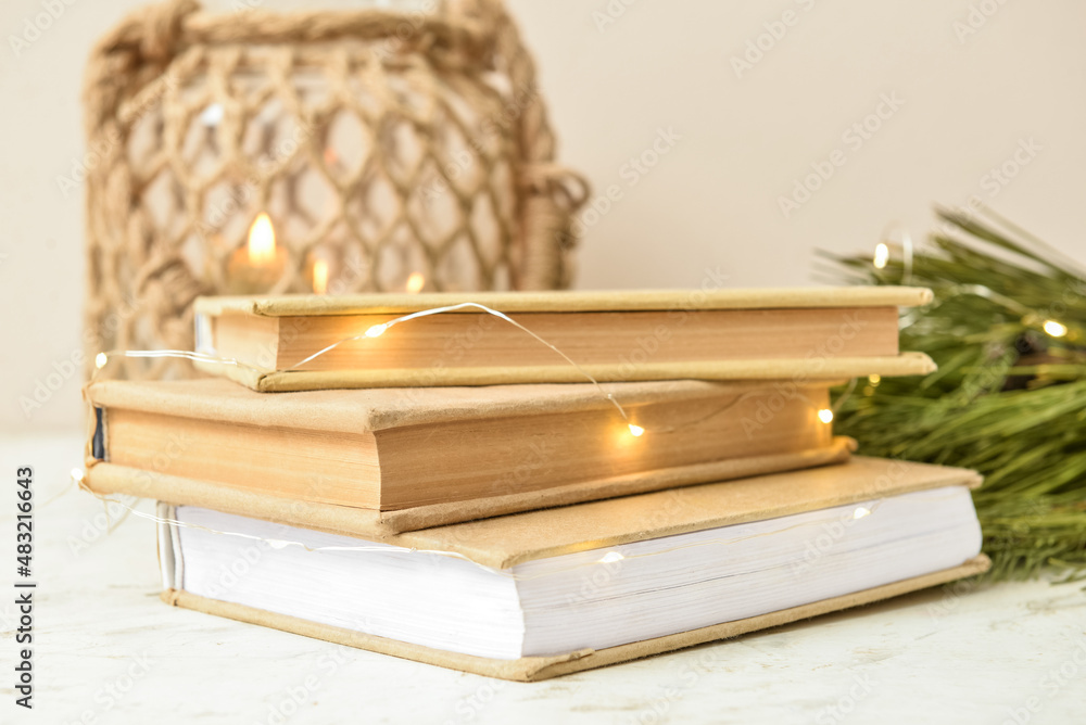 Stack of books with glowing lights on table, closeup