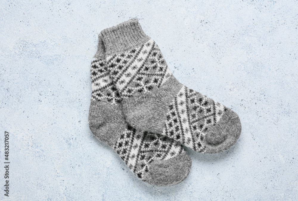 Pair of warm socks on light background