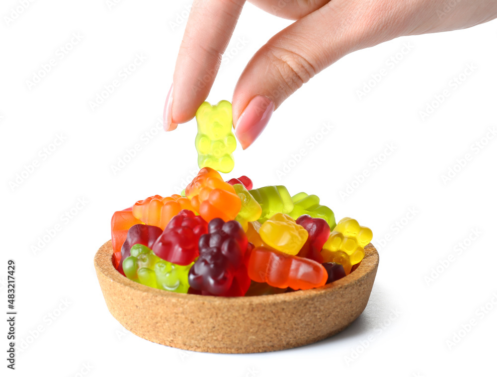 Woman eating tasty jelly bears on white background