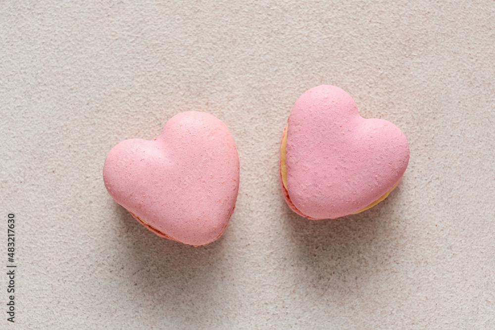 tasty heart-shaped macaroons on light background