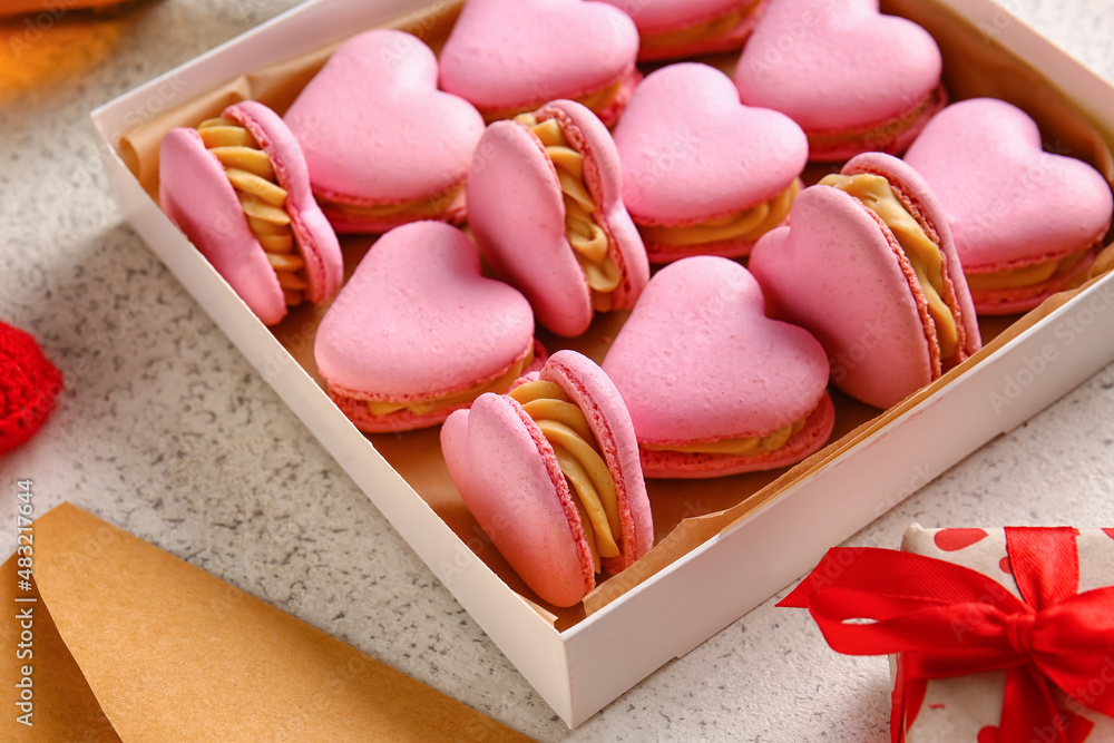 Box with tasty heart-shaped macaroons on light background, closeup