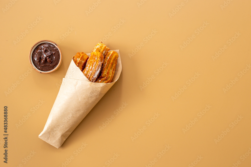 Street food dessert churros in paper bag with sugar