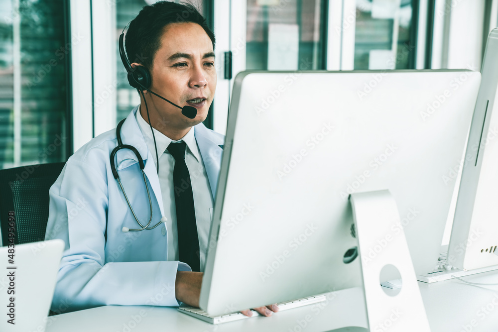 Doctor wearing headset talking actively on video call in a clinic or hospital . Concept of telehealt