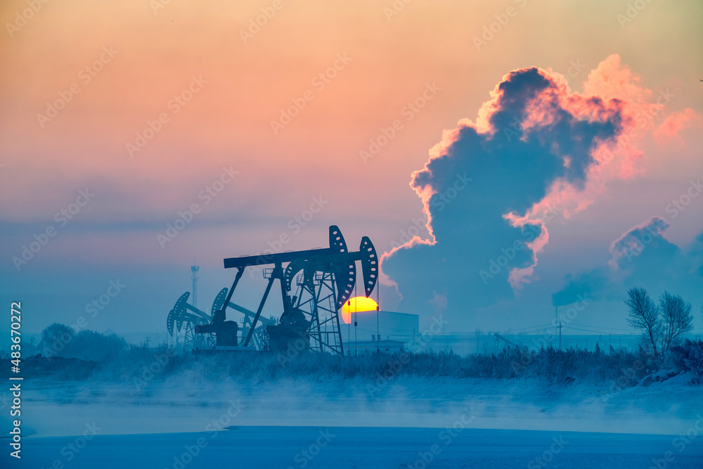 The oil pumping units in lakeside in winter in Daqing oil fields, China.