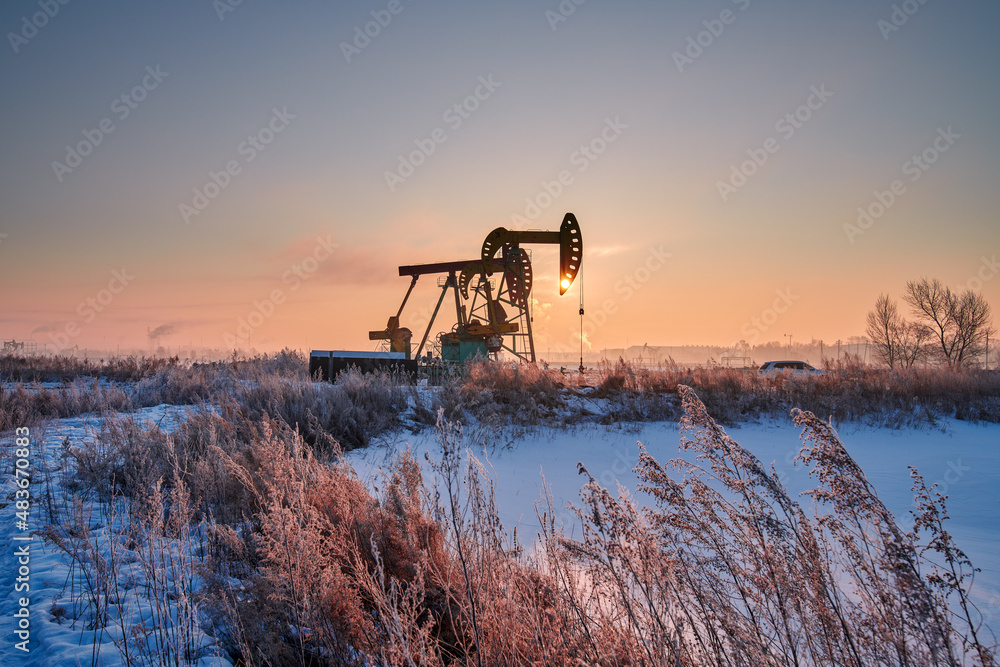 The oil pumping units in lakeside in winter in Daqing oil fields, China.