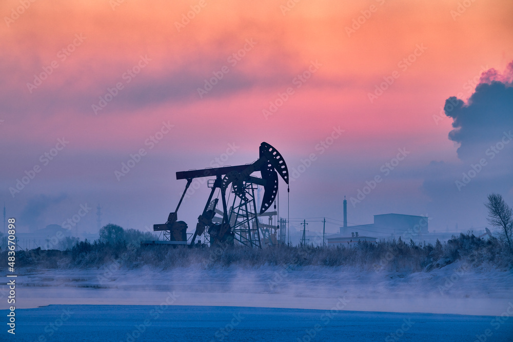 The oil pumping units in lakeside in winter in Daqing oil fields, China.