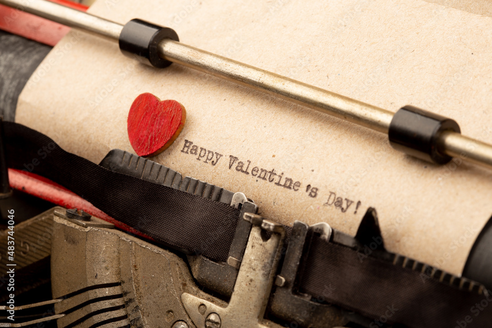 Happy Valentine`s day - phrase on typewriter. Valentines Day greetings concept. Little red wooden he