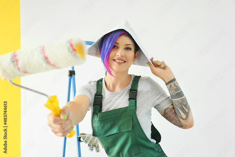 Female painter with roller near color wall