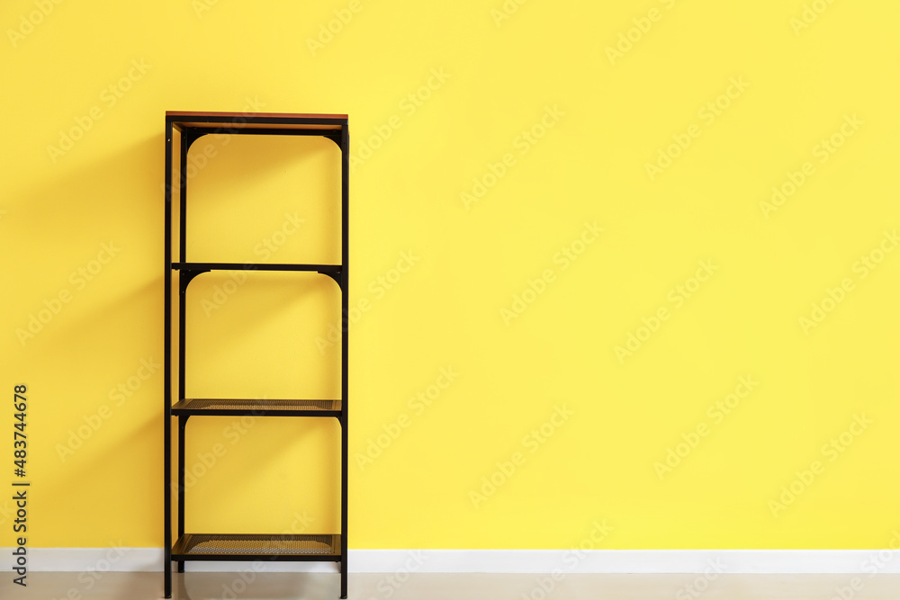 Empty standing shelving unit near yellow wall