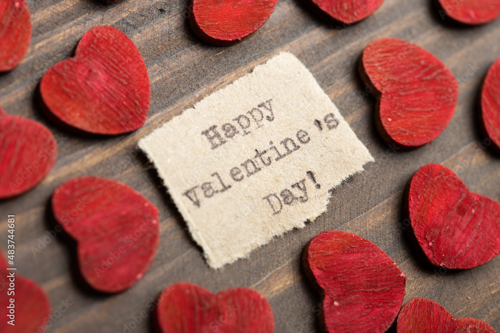 Happy Valentine`s day - typed text. Valentines Day greetings concept. Little red wooden hearts close