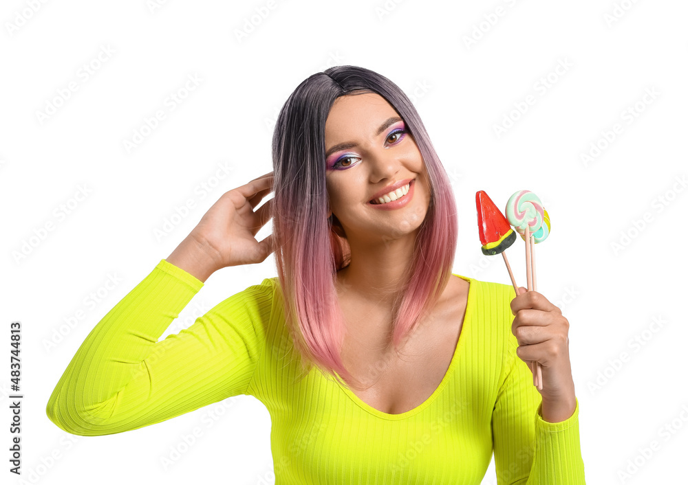 Young woman in wig with lollipop in shape of watermelon on white background