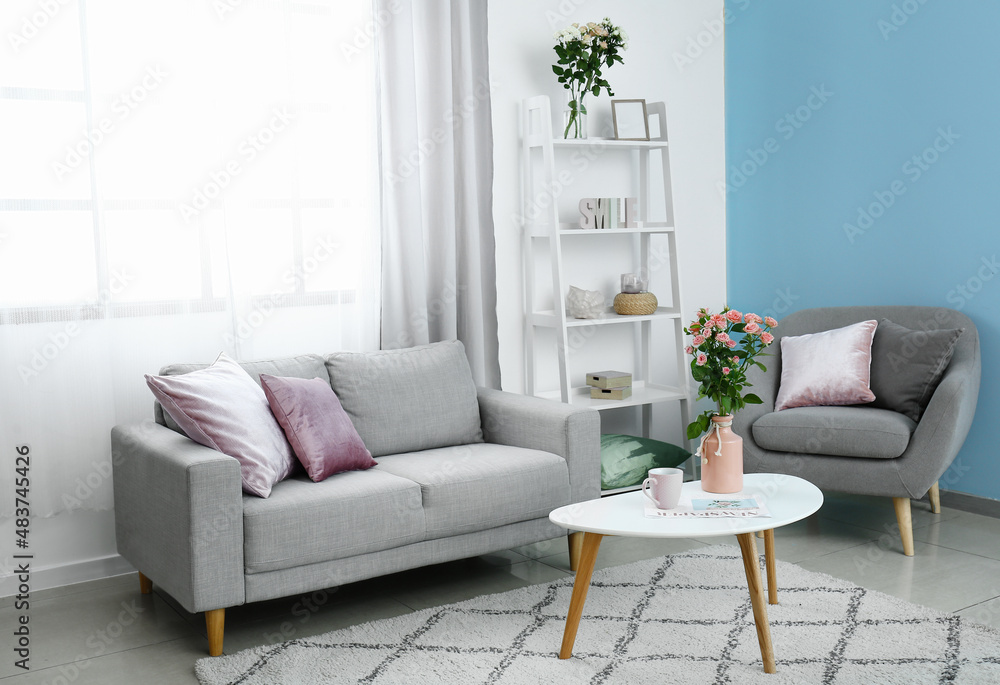 Vase with bouquet of beautiful fresh roses on table in room