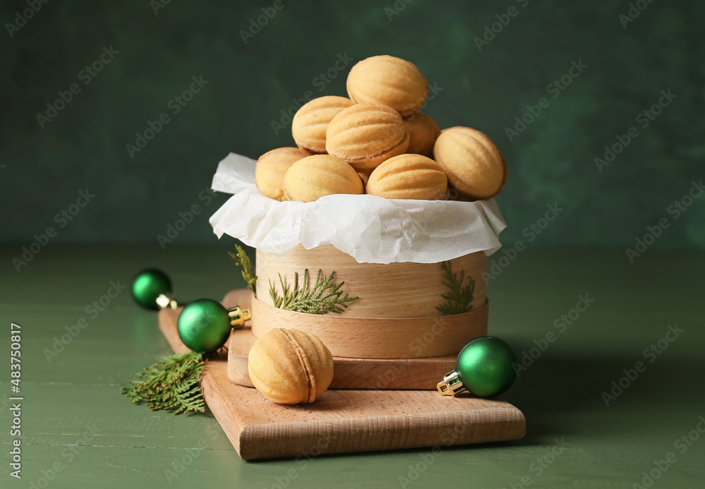 Box full of tasty walnut shaped cookies with boiled condensed milk, thuja branches and Christmas bal