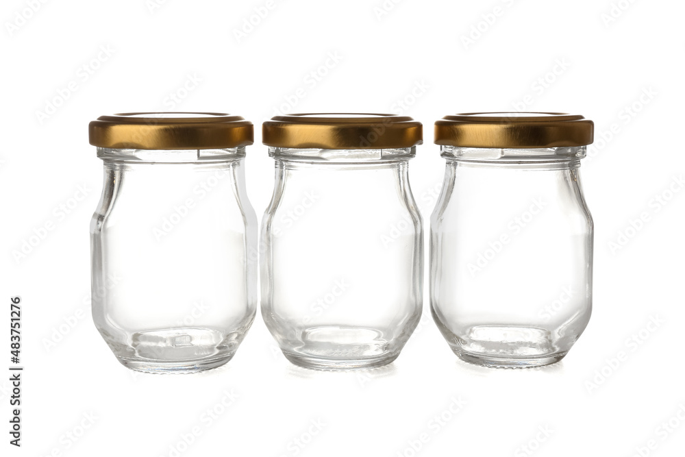 Glass jars with golden caps isolated on white background