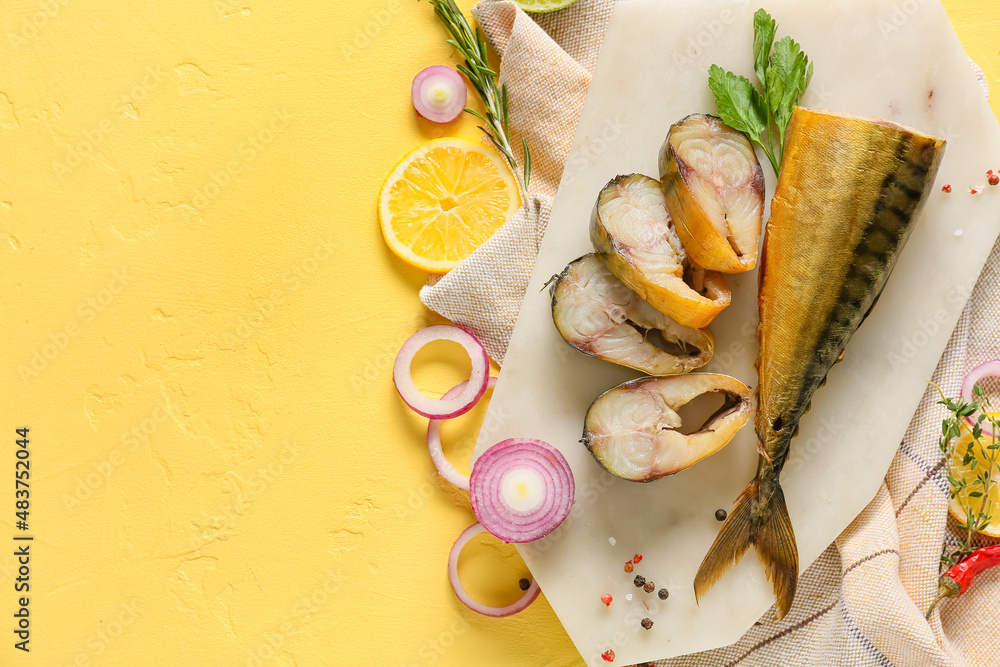 Board with pieces of smoked mackerel fish on yellow background