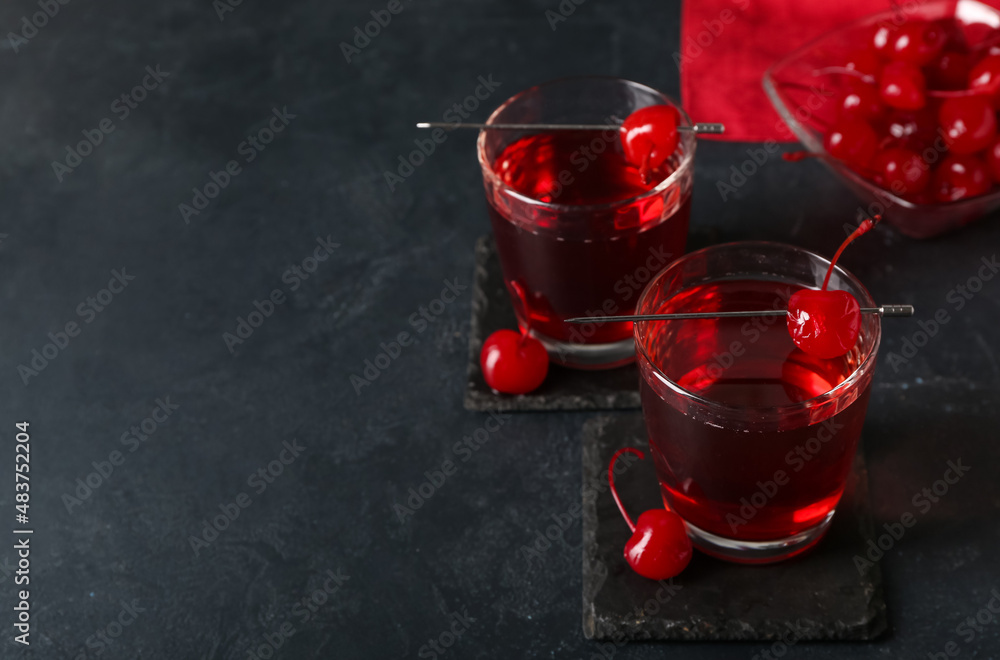 Glasses of tasty Manhattan cocktail on black background