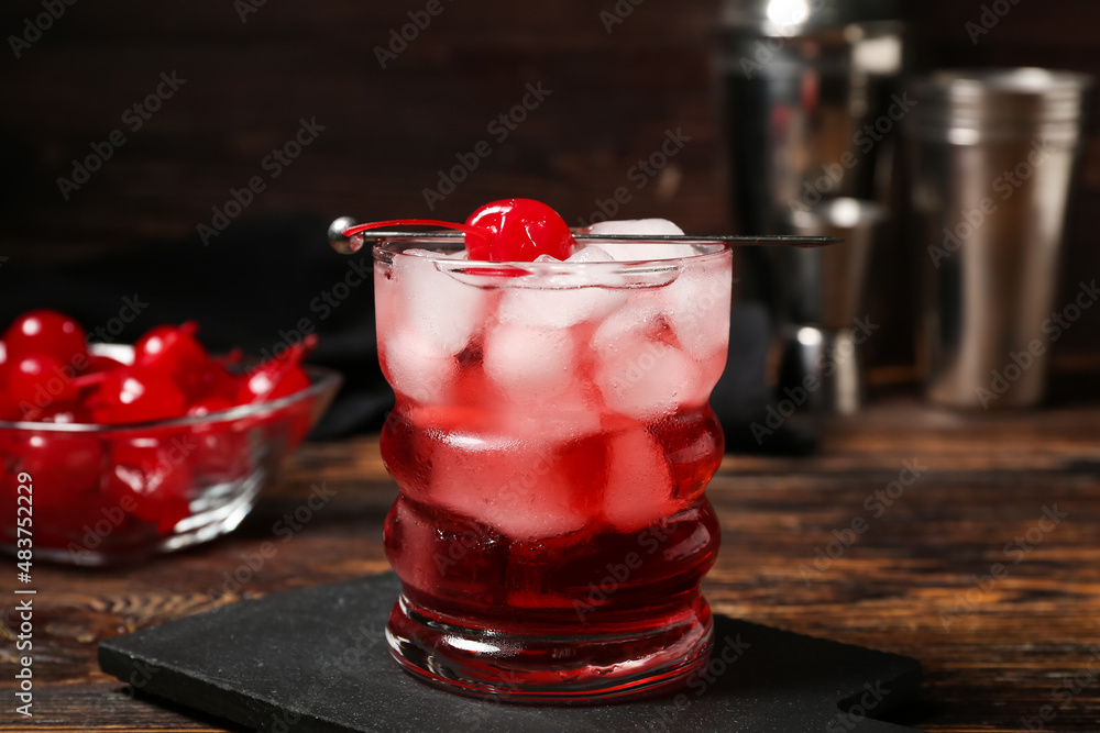 Glass of tasty Manhattan cocktail on dark wooden background