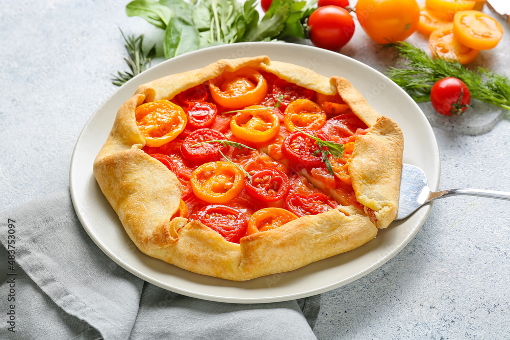 Plate with tasty tomato galette on light background, closeup