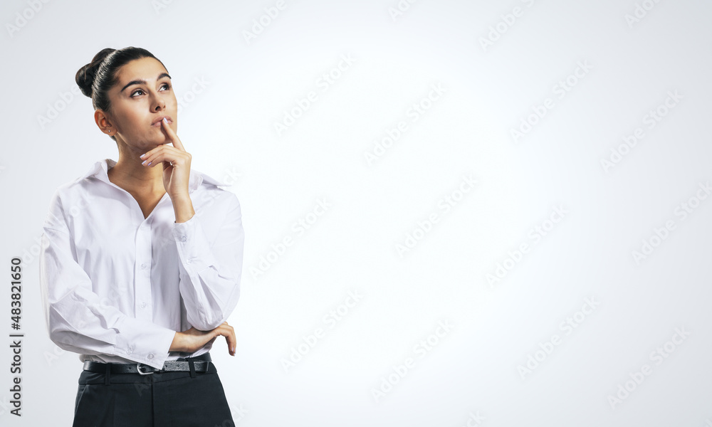 Thinking concept with pensive girl in white shirt on abstract white background with place for your t