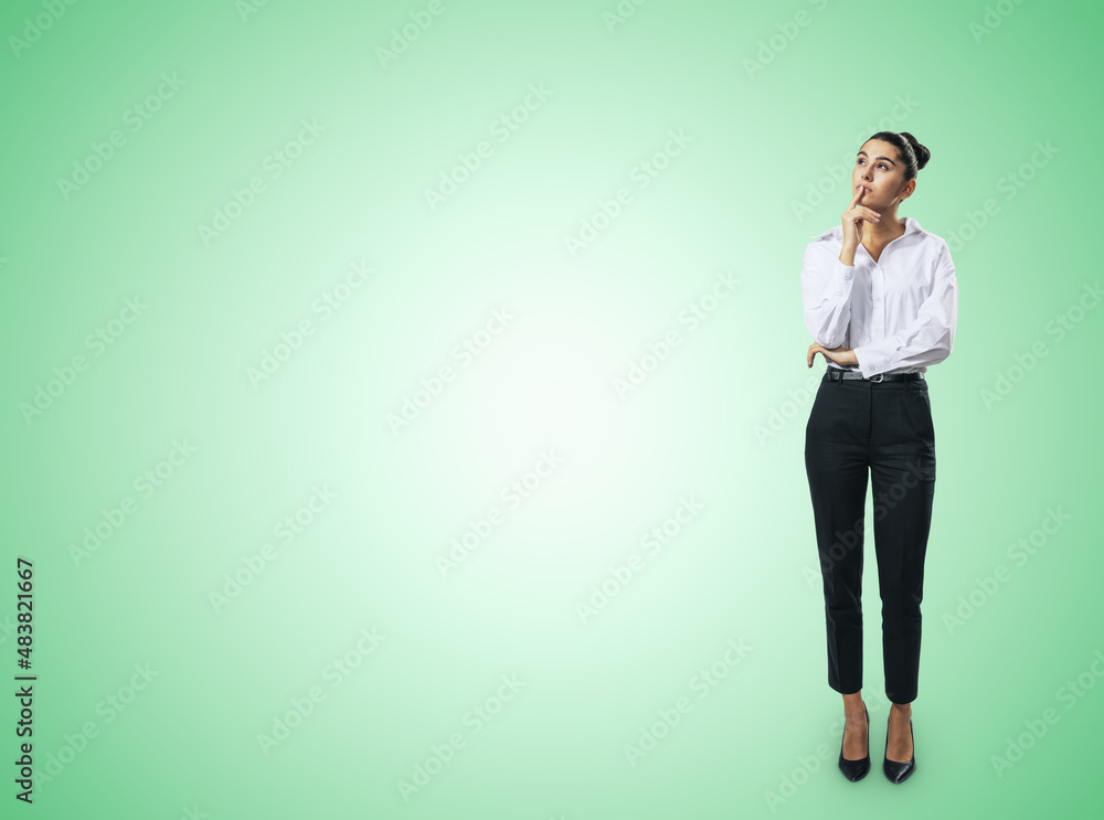 Thinking concept with pensive businesswoman in white shirt standing on abstract green background wit