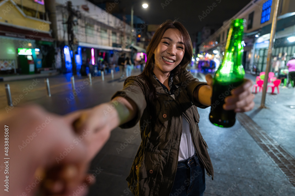 亚洲女旅行者的肖像，牵着男朋友的手，走在街上