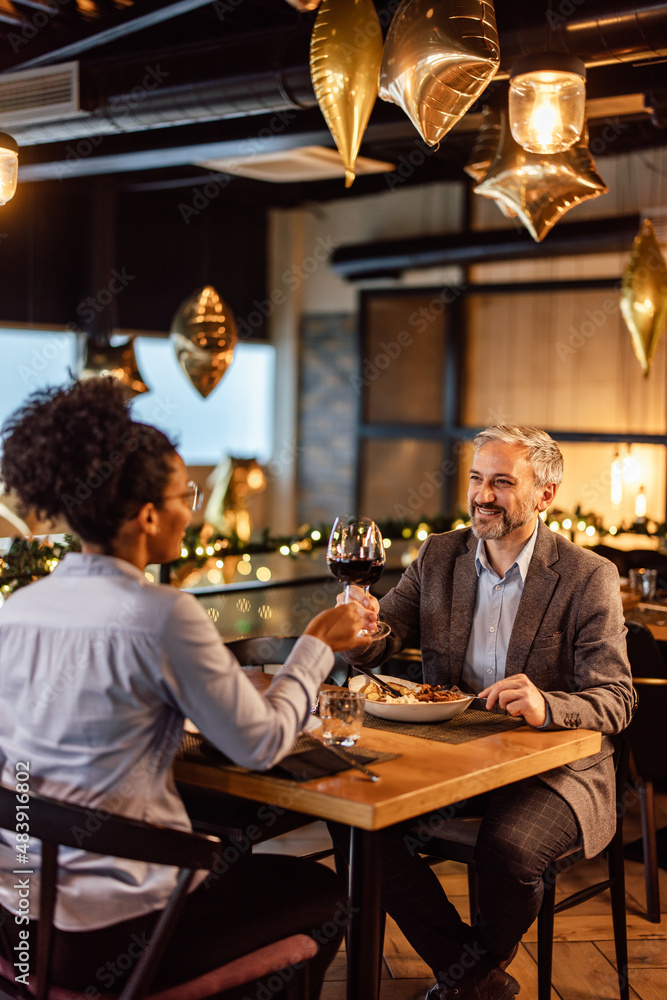 Happy diverse colleagues, saluting each other, at a business lunch.