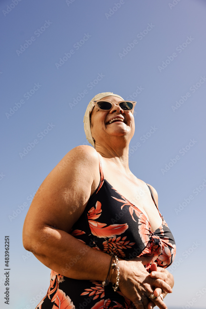 Cheerful senior woman laughing happily in swimwear