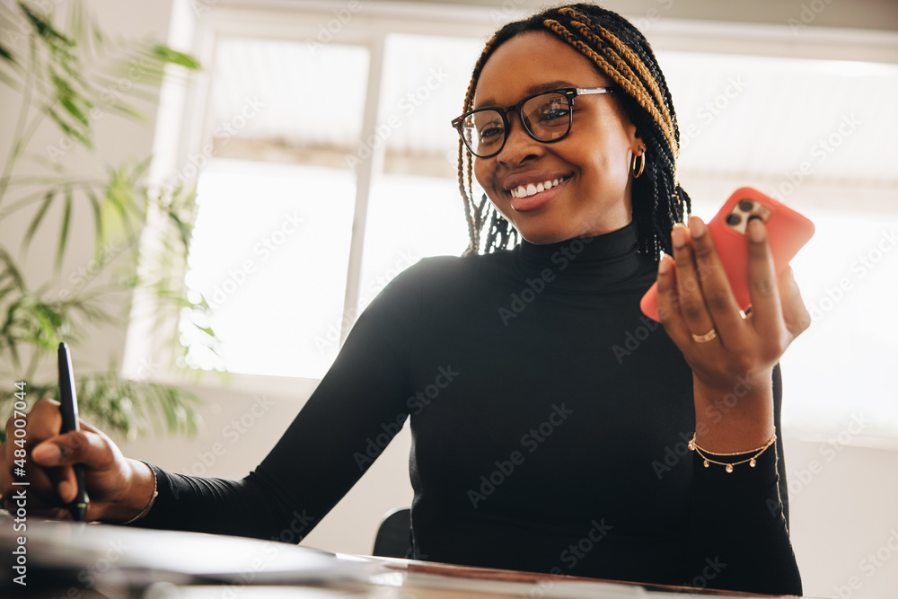 Smiling graphic designer taking a phone call