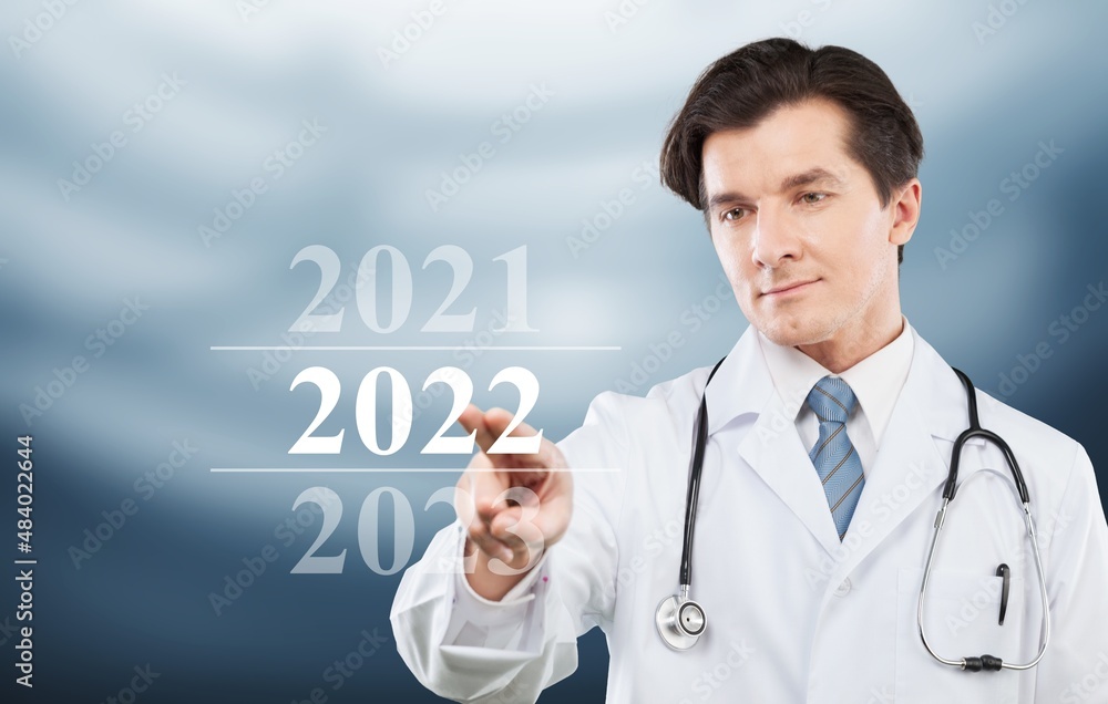 Doctor clicks on new year 2022 on hospital background.