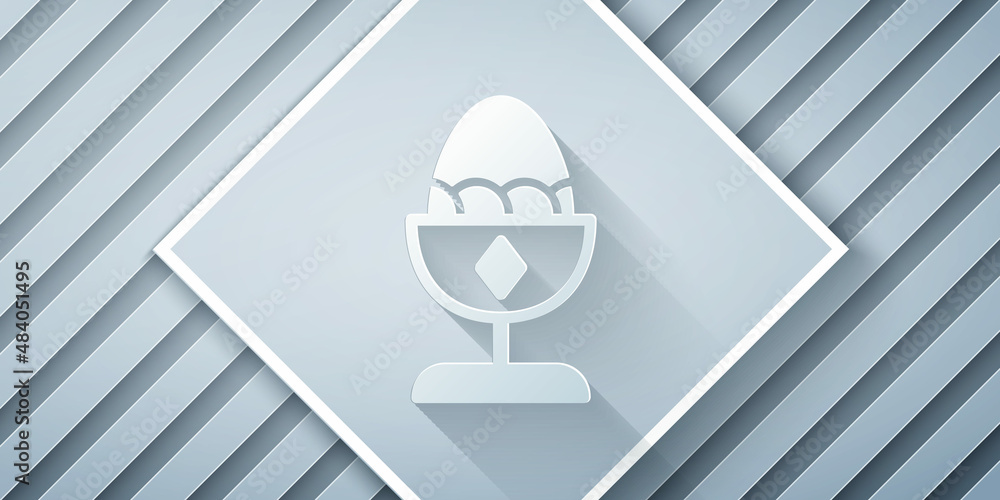 Paper cut Chicken egg on a stand icon isolated on grey background. Paper art style. Vector