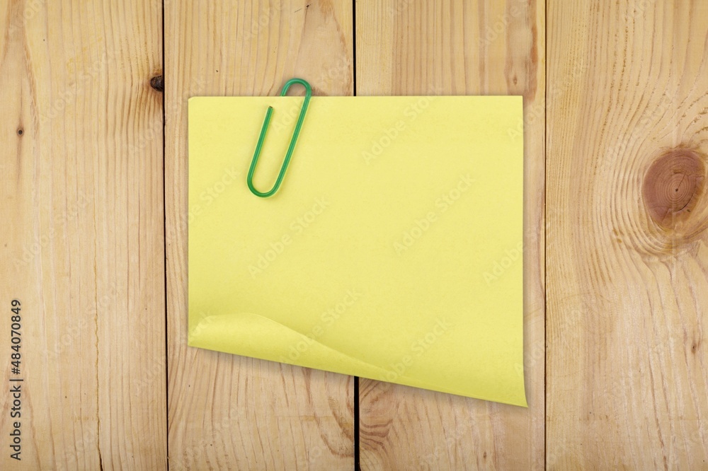 Blank yellow adhesive notes with wooden background.