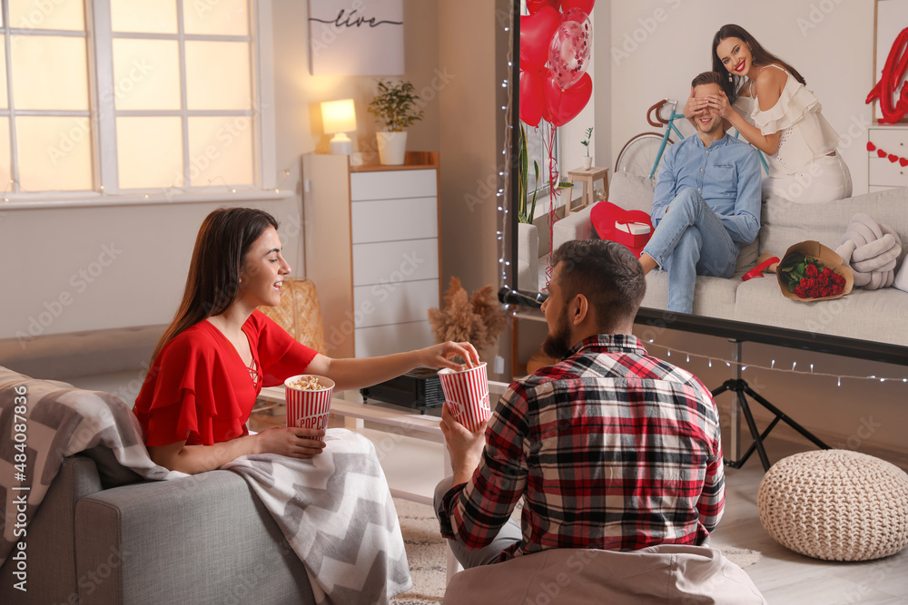 Young couple during watching of romantic movie at home