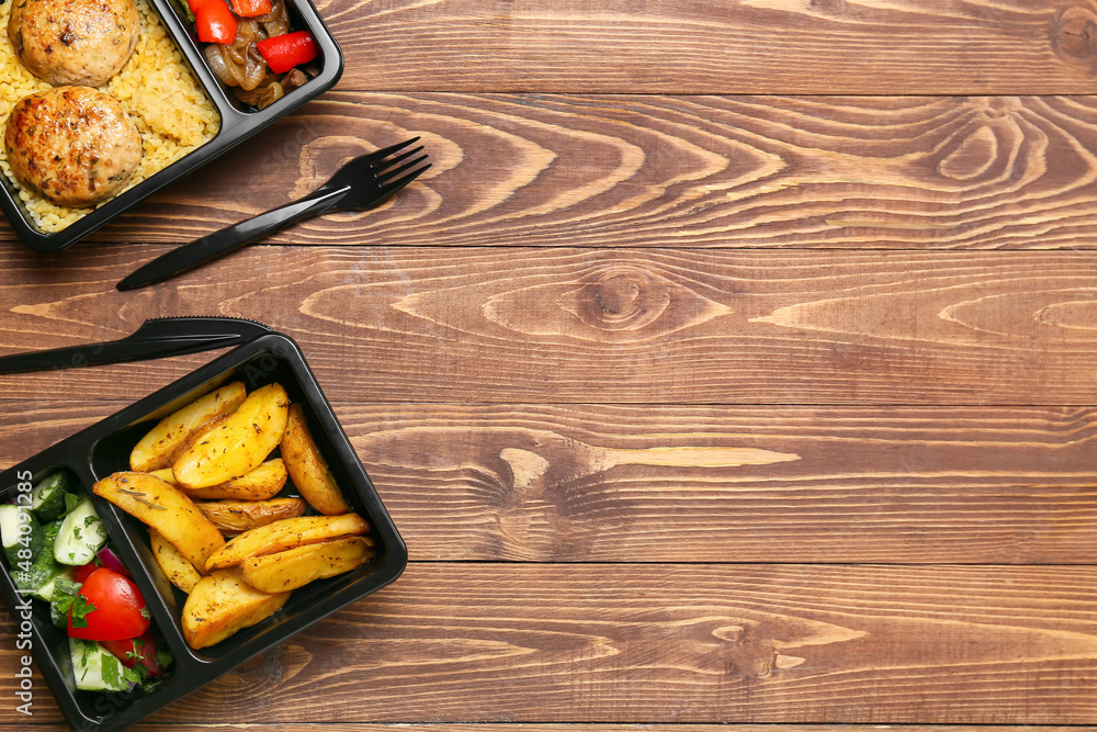 Takeaway boxes with delicious food and cutlery on wooden background