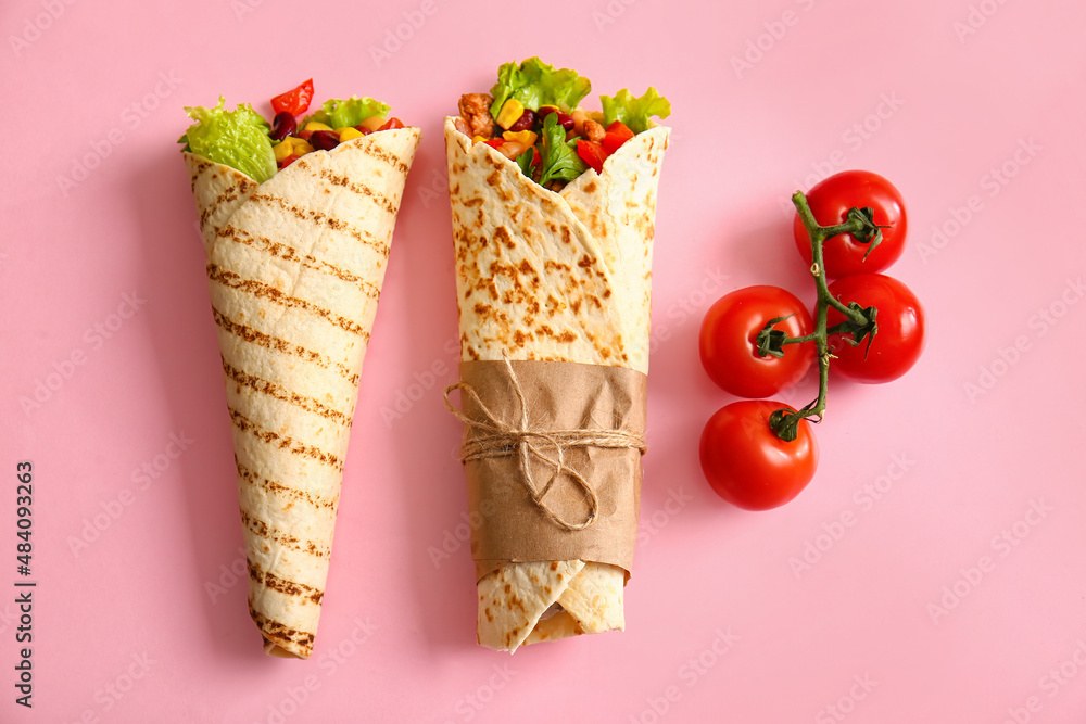 Delicious burritos and tomatoes on pink background