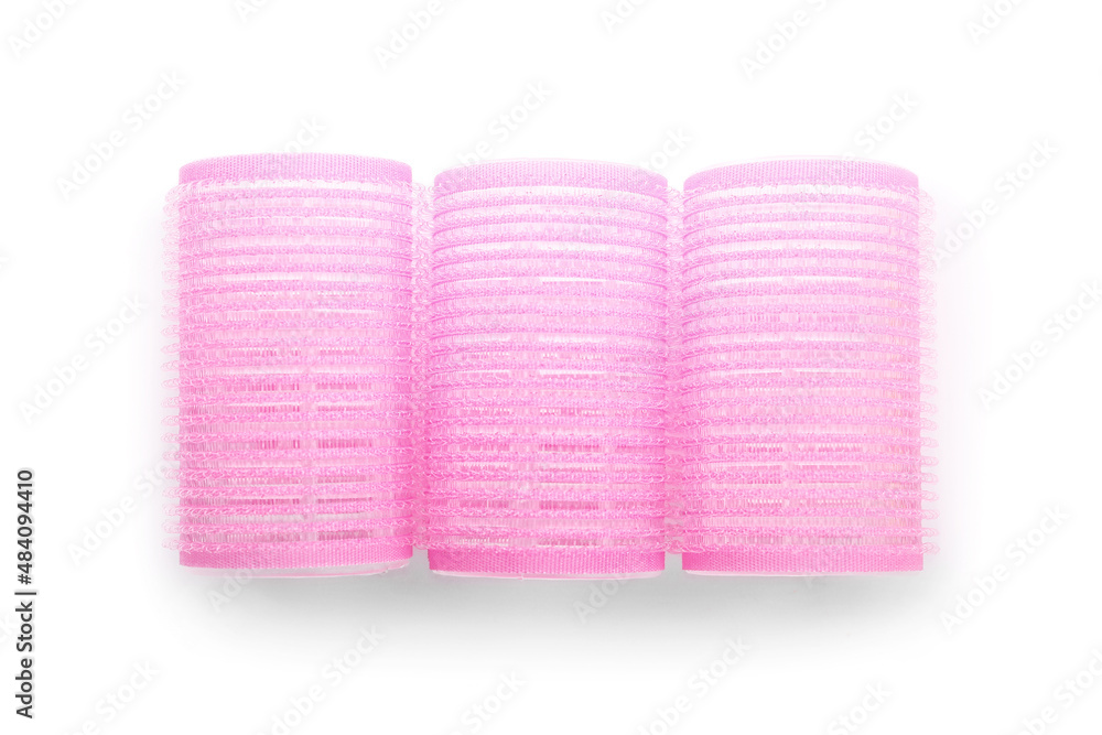 Pink hair curlers on light background