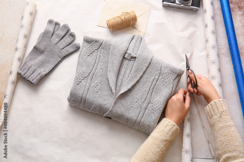 Woman making beautiful gift on table