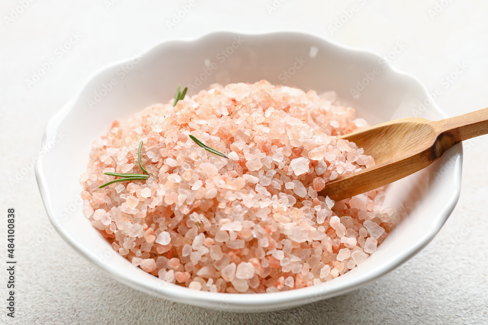 Bowl of pink sea salt on light background, closeup