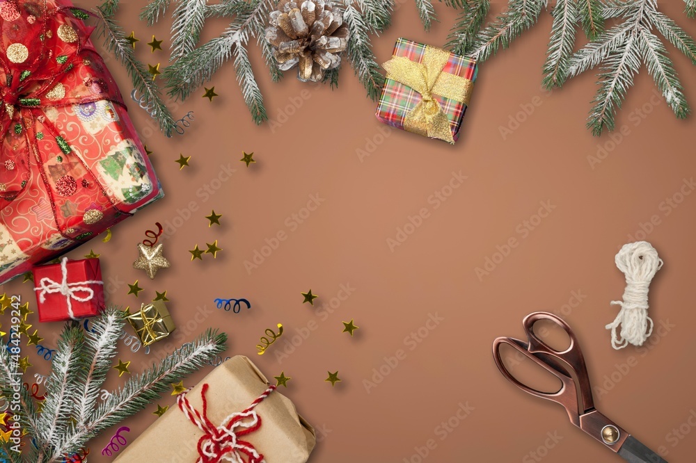 Gift wraped in craft paper and red bow on brown background. Christmas gift box