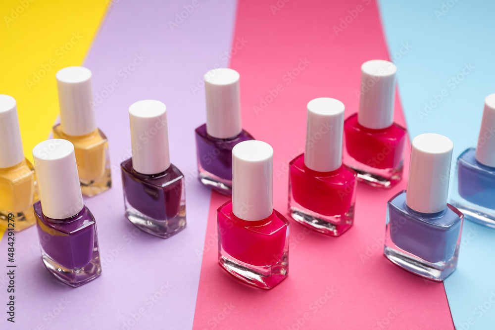 Set of nail polish bottles on color background