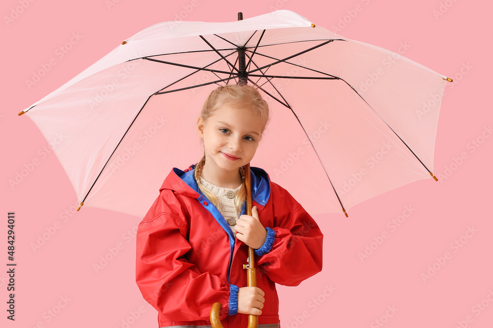 Little girl in stylish raincoat and with umbrella on color background